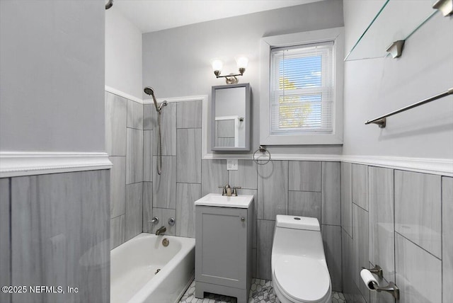 bathroom featuring a wainscoted wall, shower / tub combination, vanity, and toilet