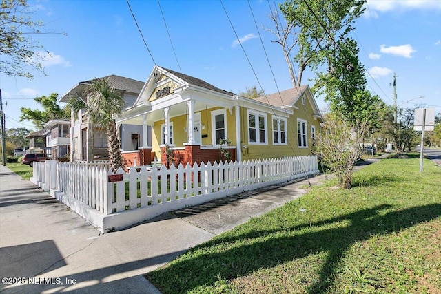 view of front of property with a fenced front yard, covered porch, and a front yard