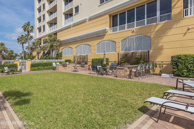 surrounding community featuring fence, a patio area, and a lawn