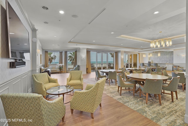 dining room featuring a healthy amount of sunlight, a decorative wall, and a tray ceiling