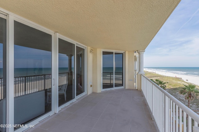 balcony with a beach view and a water view
