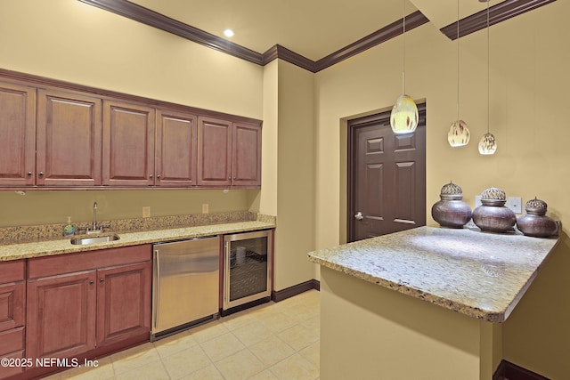 kitchen with a sink, wine cooler, ornamental molding, refrigerator, and hanging light fixtures