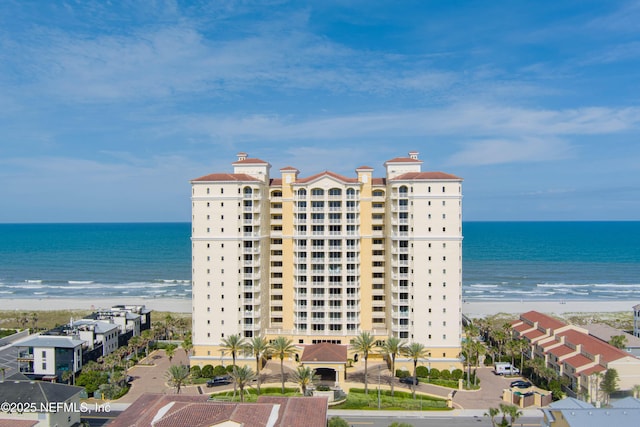 view of property with a beach view and a water view