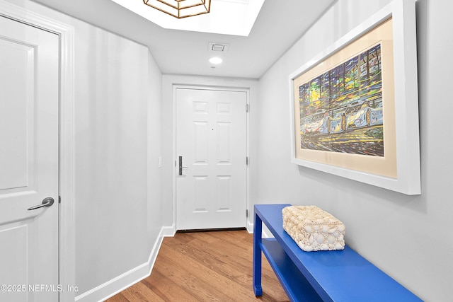 doorway with recessed lighting, visible vents, baseboards, a skylight, and wood finished floors