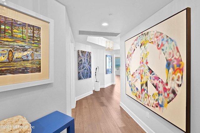 hall with recessed lighting, visible vents, wood finished floors, and baseboards
