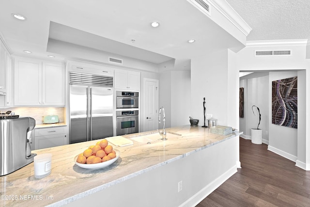 kitchen featuring recessed lighting, light stone countertops, a sink, visible vents, and appliances with stainless steel finishes