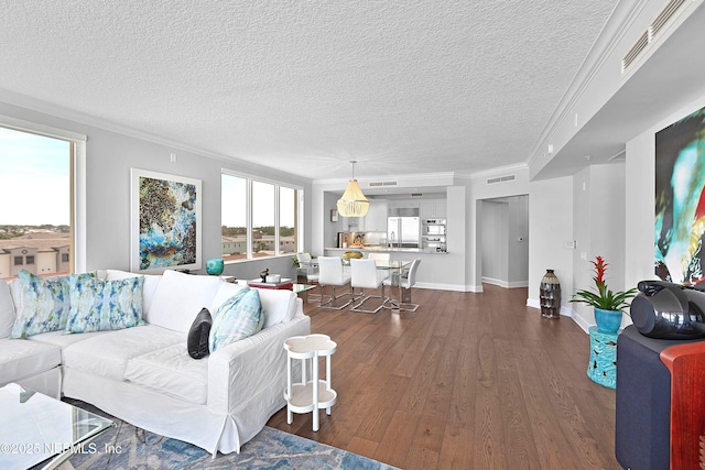 living room with baseboards, dark wood-style floors, visible vents, a textured ceiling, and crown molding