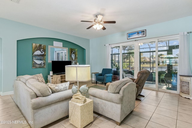 living area featuring baseboards, ceiling fan, and light tile patterned floors