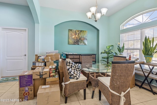 dining space featuring arched walkways, tile patterned flooring, and a chandelier
