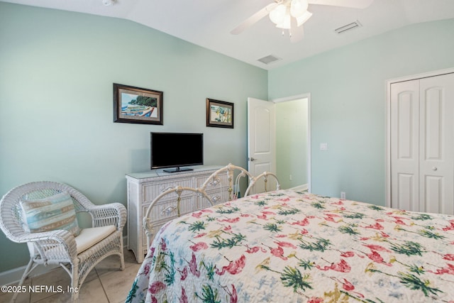 tiled bedroom with lofted ceiling, a closet, visible vents, and a ceiling fan