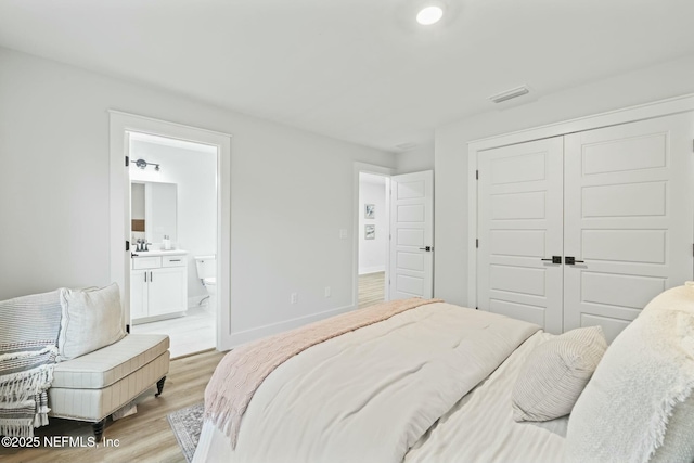 85199 Southern Creek Blvd, Fernandina Beach, FL 32034 - bedroom featuring a closet, baseboards, a sink, light wood finished floors, and ensuite bath