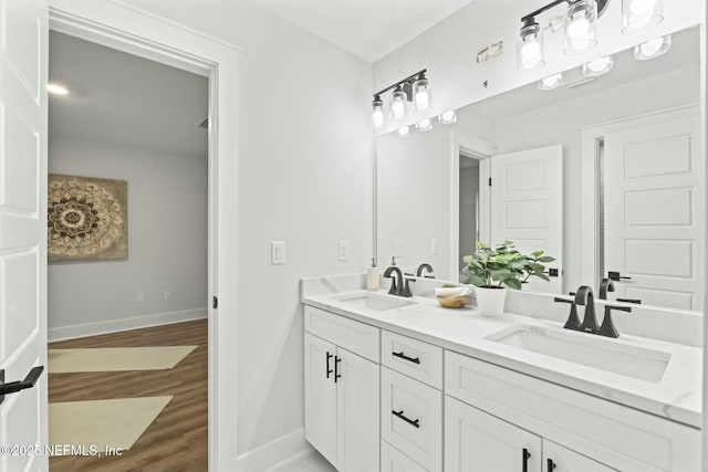 85199 Southern Creek Blvd, Fernandina Beach, FL 32034 - bathroom with baseboards, a sink, wood finished floors, and double vanity