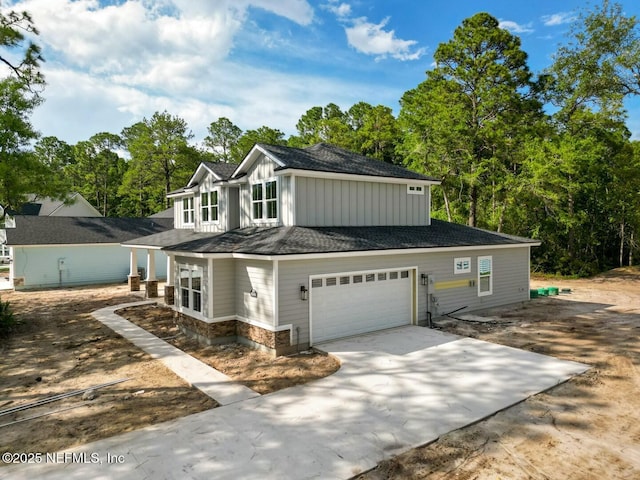 85084 Southern Creek Blvd, Fernandina Beach, FL 32034 - view of property featuring stone siding, a shingled roof, board and batten siding, an attached garage, and driveway