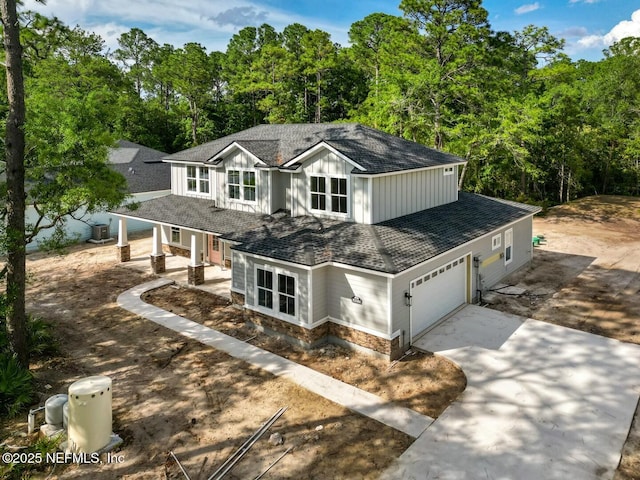 85084 Southern Creek Blvd, Fernandina Beach, FL 32034 - view of front of property featuring a garage, covered porch, stone siding, board and batten siding, and concrete driveway