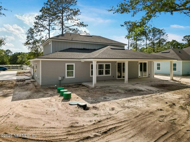 85084 Southern Creek Blvd, Fernandina Beach, FL 32034 - rear view of house featuring roof with shingles, board and batten siding, and a patio area