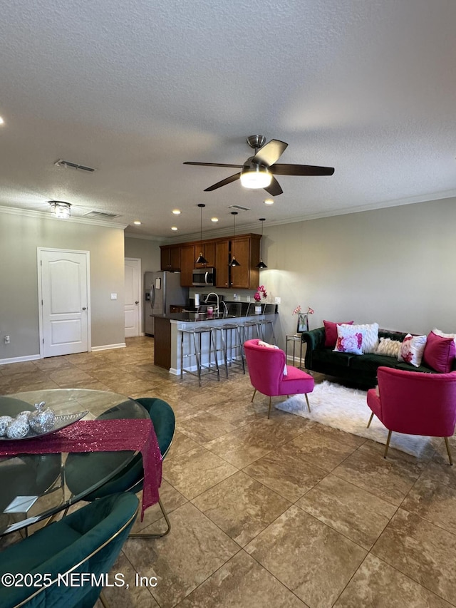 528 Sherwood Oaks Dr, Orange Park, FL 32073 - living room featuring a ceiling fan, baseboards, visible vents, ornamental molding, and a textured ceiling