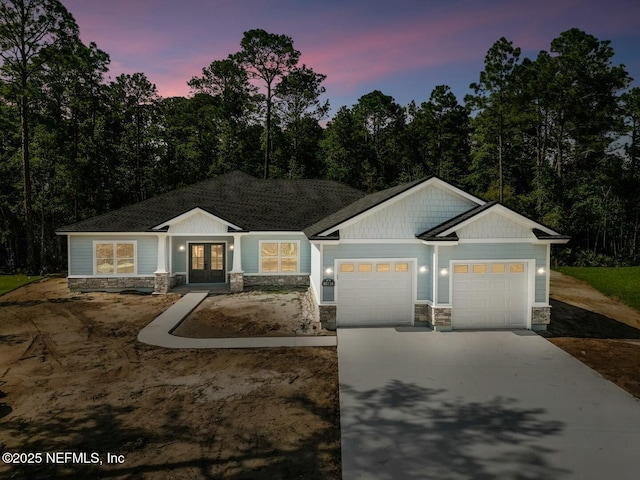 85118 Southern Creek Blvd, Fernandina Beach, FL 32034 - view of front of house featuring concrete driveway, an attached garage, french doors, and stone siding