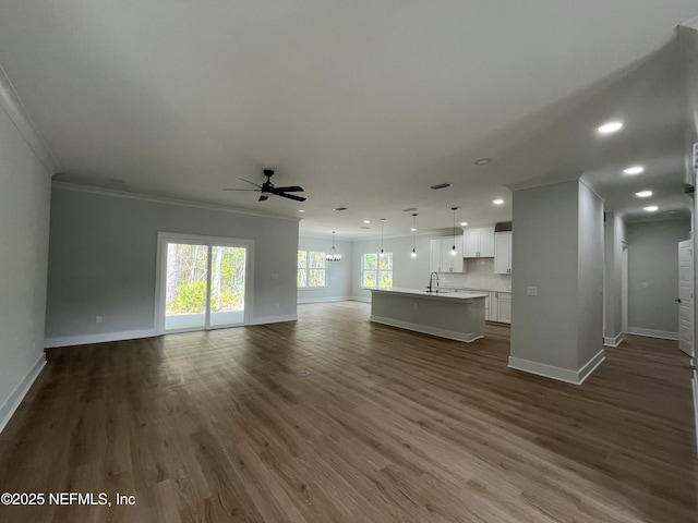 85118 Southern Creek Blvd, Fernandina Beach, FL 32034 - unfurnished living room featuring crown molding, a sink, baseboards, and ceiling fan with notable chandelier