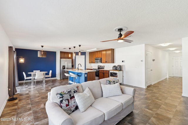 living room with baseboards and ceiling fan