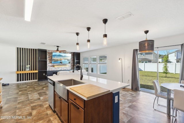kitchen with dishwasher, hanging light fixtures, visible vents, and a sink