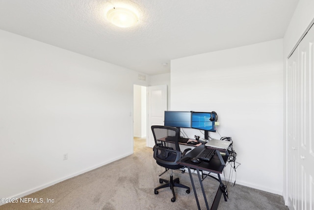 office space featuring baseboards, a textured ceiling, and carpet