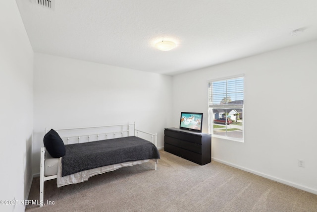 carpeted bedroom featuring visible vents and baseboards