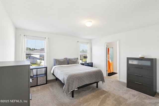 bedroom featuring baseboards and light carpet