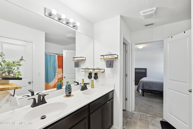 bathroom with double vanity, visible vents, and a sink