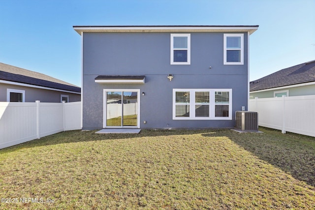 back of property with a fenced backyard, central air condition unit, stucco siding, and a yard