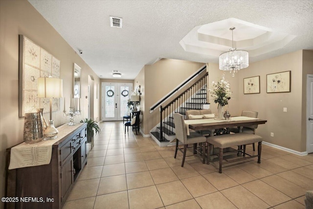 1074 Spanish Bay Ct, Orange Park, FL 32065 - dining room featuring stairs, an inviting chandelier, light tile patterned floors, and a raised ceiling