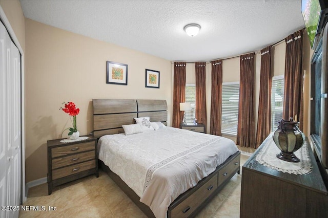1074 Spanish Bay Ct, Orange Park, FL 32065 - bedroom featuring a closet, multiple windows, light tile patterned flooring, and a textured ceiling