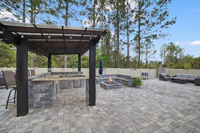 1074 Spanish Bay Ct, Orange Park, FL 32065 - view of patio / terrace with a pergola, an outdoor living space with a fire pit, fence, and outdoor dry bar