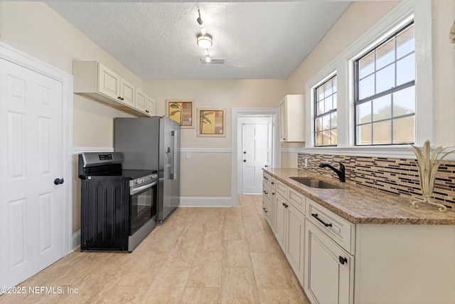 3824 Springfield Blvd, Jacksonville, FL 32206 - kitchen with light stone countertops, decorative backsplash, white cabinets, stainless steel appliances, and a sink