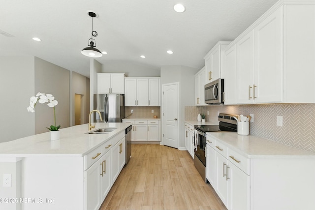 kitchen with a sink, white cabinetry, appliances with stainless steel finishes, light wood finished floors, and vaulted ceiling