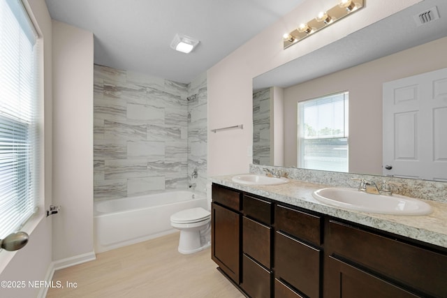 full bathroom featuring double vanity, visible vents, toilet, and a sink