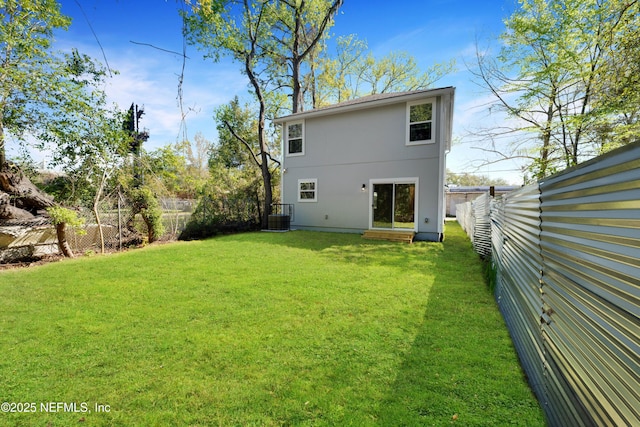 back of house with a fenced backyard, cooling unit, and a yard