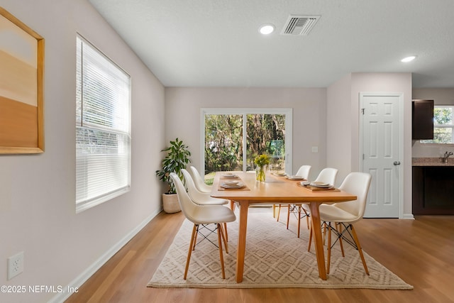 dining room with recessed lighting, baseboards, visible vents, and light wood finished floors