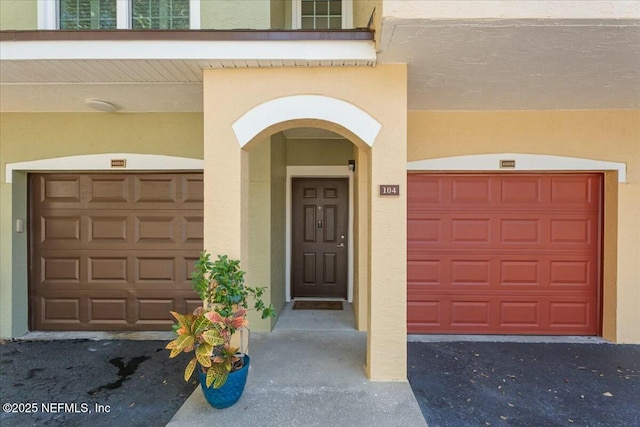 entrance to property with stucco siding and an attached garage