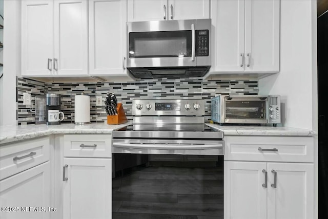 kitchen with white cabinetry, decorative backsplash, appliances with stainless steel finishes, and a toaster