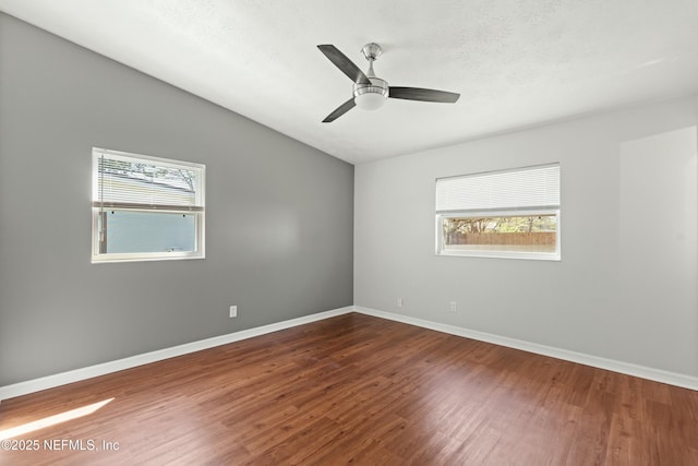 spare room with vaulted ceiling, a ceiling fan, baseboards, and wood finished floors
