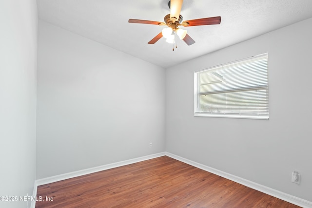 empty room with a textured ceiling, wood finished floors, baseboards, and ceiling fan