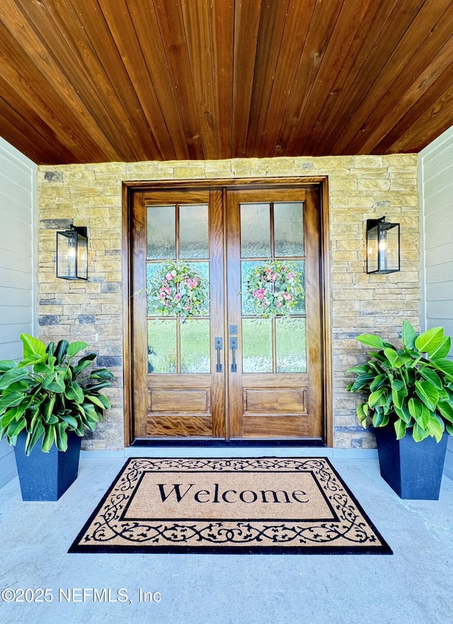 property entrance with french doors and stone siding