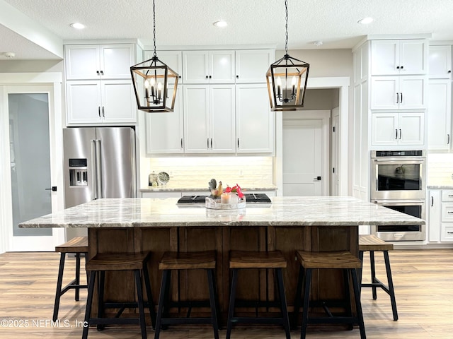 kitchen with white cabinets, stainless steel appliances, and a chandelier