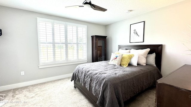 bedroom with a ceiling fan, carpet, baseboards, and a textured ceiling