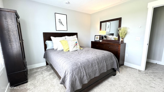 bedroom with baseboards, carpet floors, and a textured ceiling