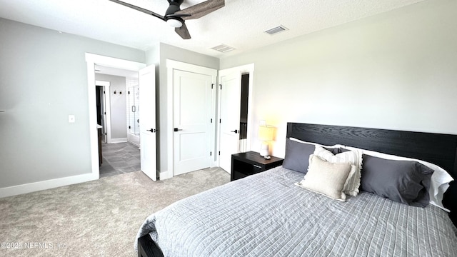 carpeted bedroom featuring ceiling fan, baseboards, visible vents, and a textured ceiling