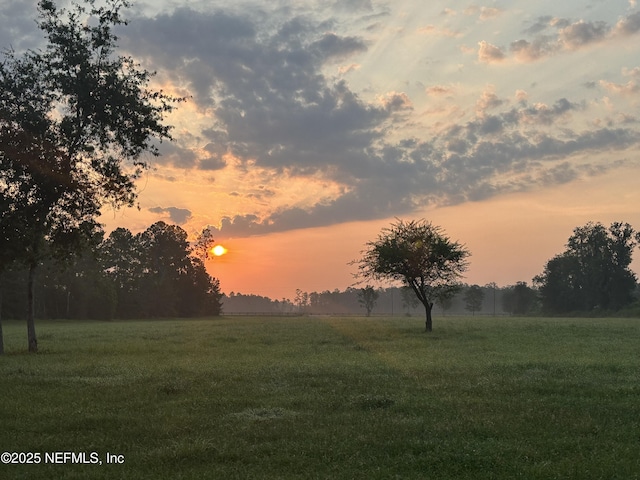 nature at dusk featuring a rural view