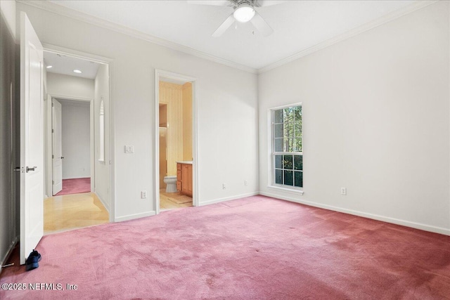 unfurnished bedroom with crown molding, baseboards, ceiling fan, light colored carpet, and ensuite bath