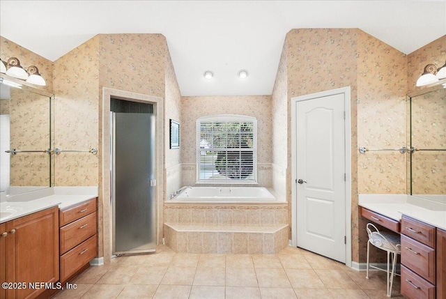 full bathroom featuring lofted ceiling, a garden tub, vanity, and wallpapered walls