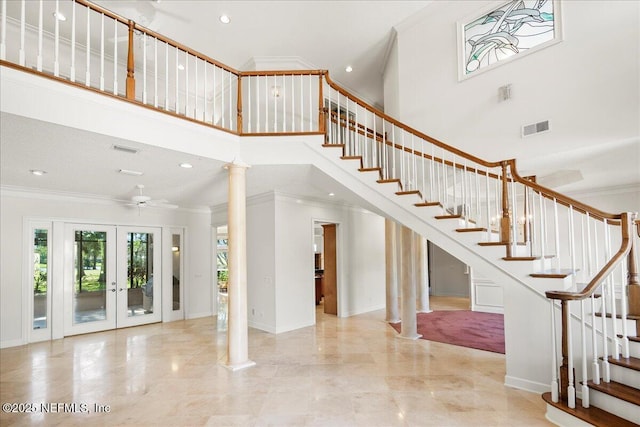 stairs featuring visible vents, french doors, crown molding, and a high ceiling